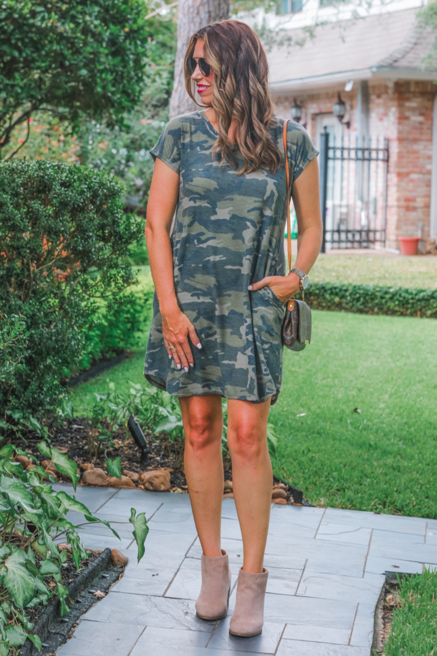 an oversized green A-line pocket dress with a V-neckline, short sleeves, side pockets, a curved hem, and a terry cloth texture