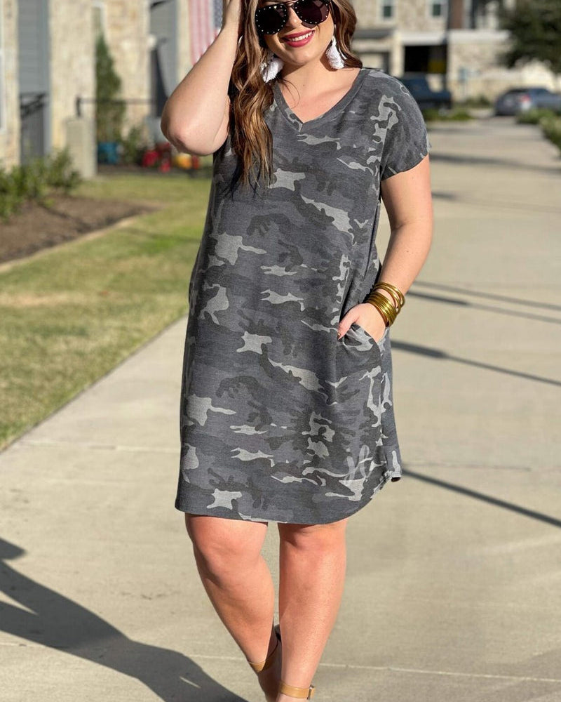 an oversized grey A-line pocket dress with a V-neckline, short sleeves, side pockets, a curved hem, and a terry cloth texture