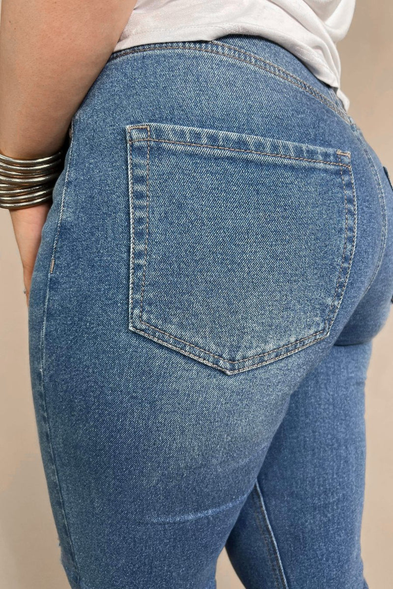 mid-rise distressed mom jeans with a raw hem, zip button-up fly, pockets, and some great stretch