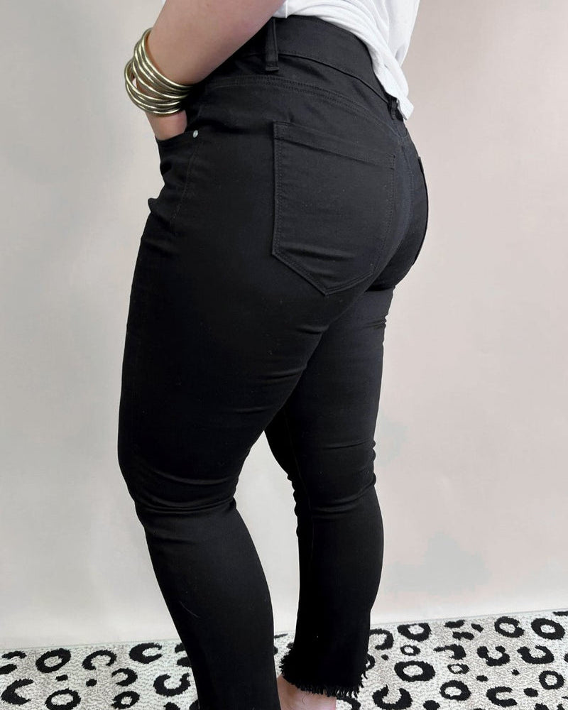 solid black mid-rise jeans with a distressed hem, zip button-up fly, pockets, and some great stretch