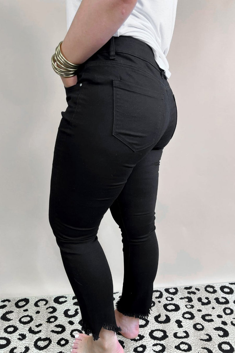 solid black mid-rise jeans with a distressed hem, zip button-up fly, pockets, and some great stretch