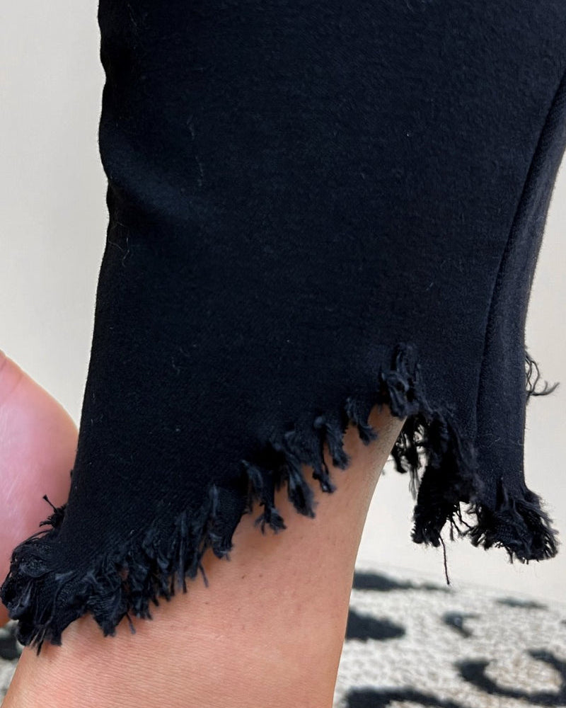 solid black mid-rise jeans with a distressed hem, zip button-up fly, pockets, and some great stretch