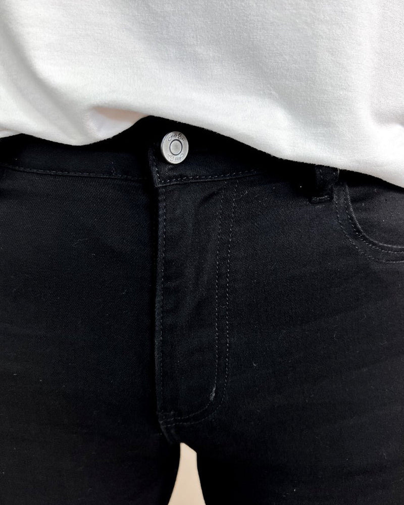 solid black mid-rise jeans with a distressed hem, zip button-up fly, pockets, and some great stretch