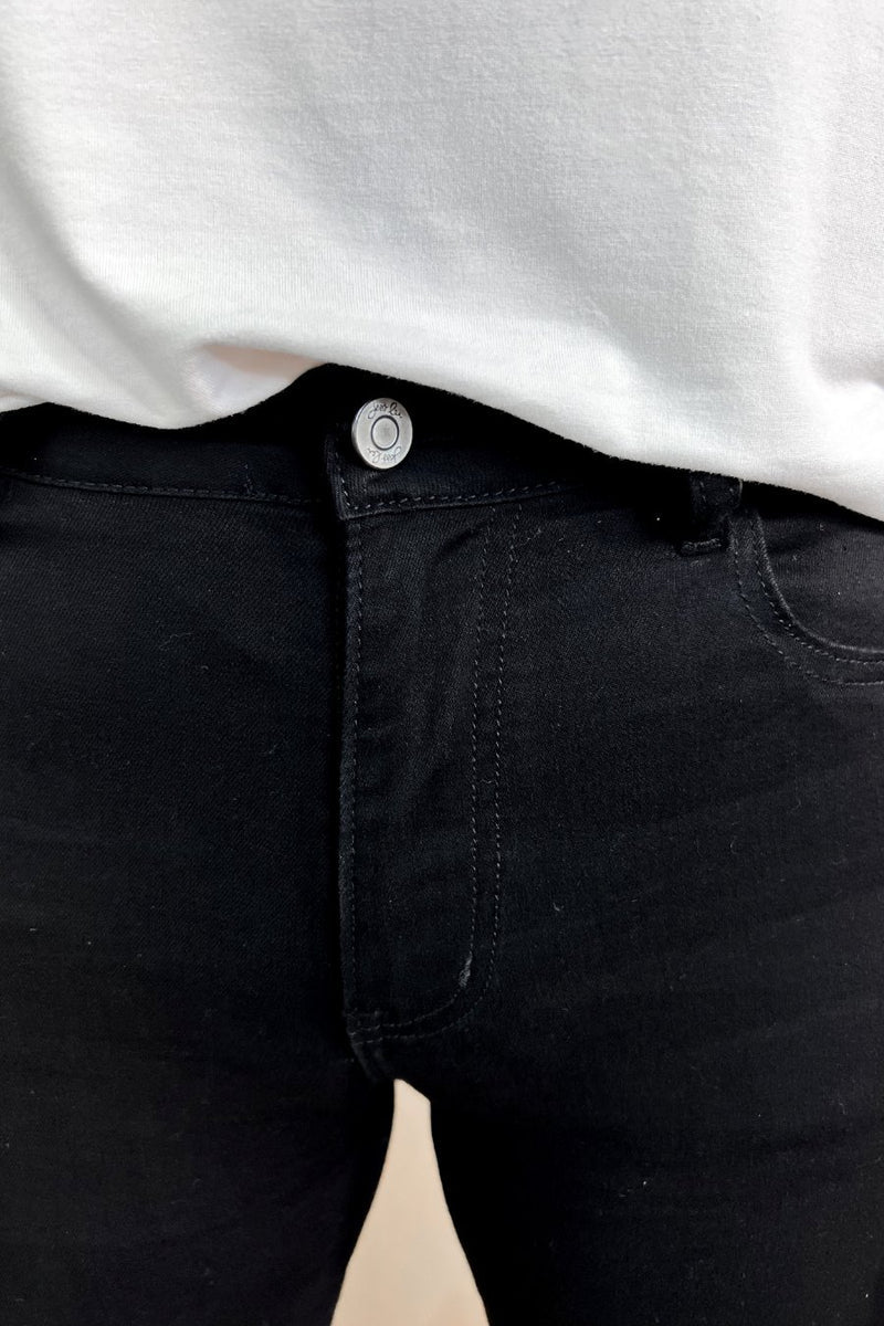 solid black mid-rise jeans with a distressed hem, zip button-up fly, pockets, and some great stretch