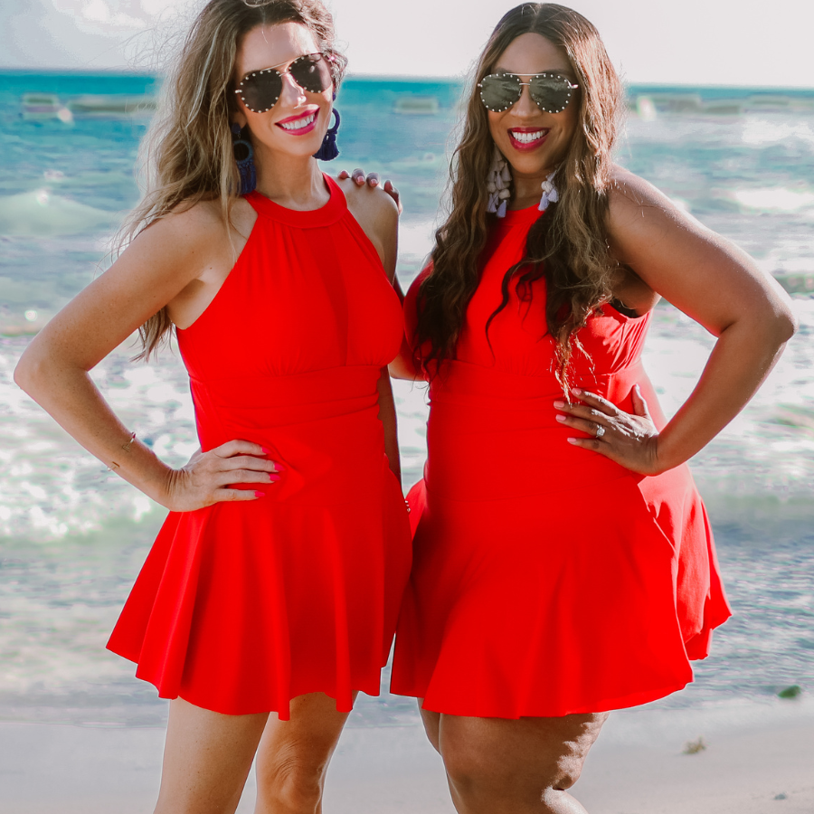solid red halter swimsuit with a mesh v-neckline leading to a back clasp closure, skirted hem, attached full coverage bottoms, and removable padding