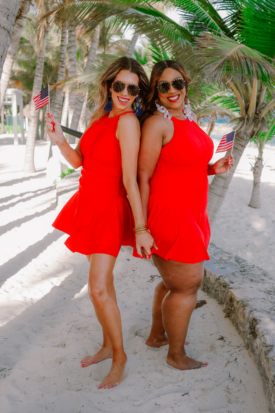 a solid red one-piece swimsuit with a halter neckline, sheer mesh V-detail, secure back clasp, removable padding, skirted hem, and attached full-coverage bottoms