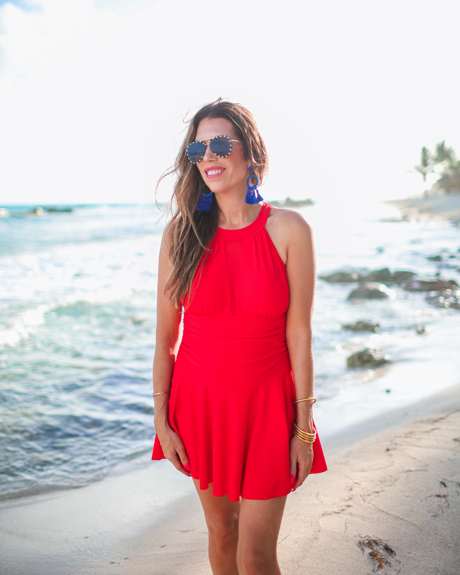 solid red halter swimsuit with a mesh v-neckline leading to a back clasp closure, skirted hem, attached full coverage bottoms, and removable padding