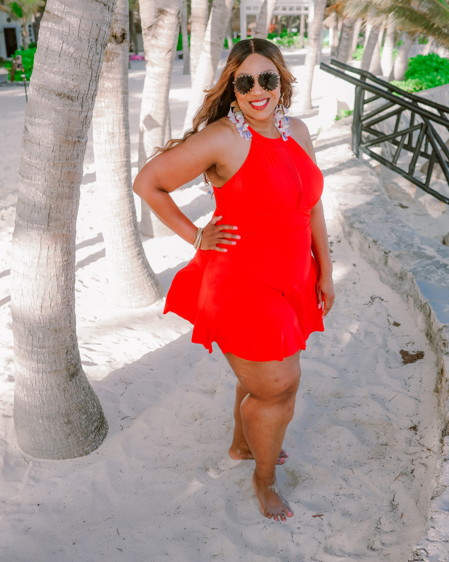 solid red halter swimsuit with a mesh v-neckline leading to a back clasp closure, skirted hem, attached full coverage bottoms, and removable padding