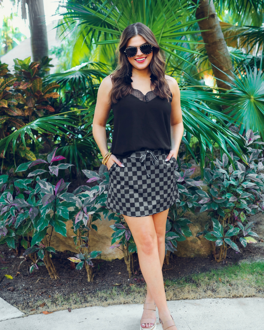 mid-rise relaxed fit everyday skort made of lightweight material with built-in black shorts, drawstring tie, an elastic band on the back, and side pockets, designed on a two-tone black checkered pattern print
