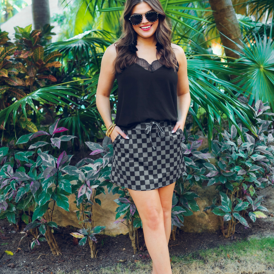 mid-rise relaxed fit everyday skort made of lightweight material with built-in black shorts, drawstring tie, an elastic band on the back, and side pockets, designed on a two-tone black checkered pattern print