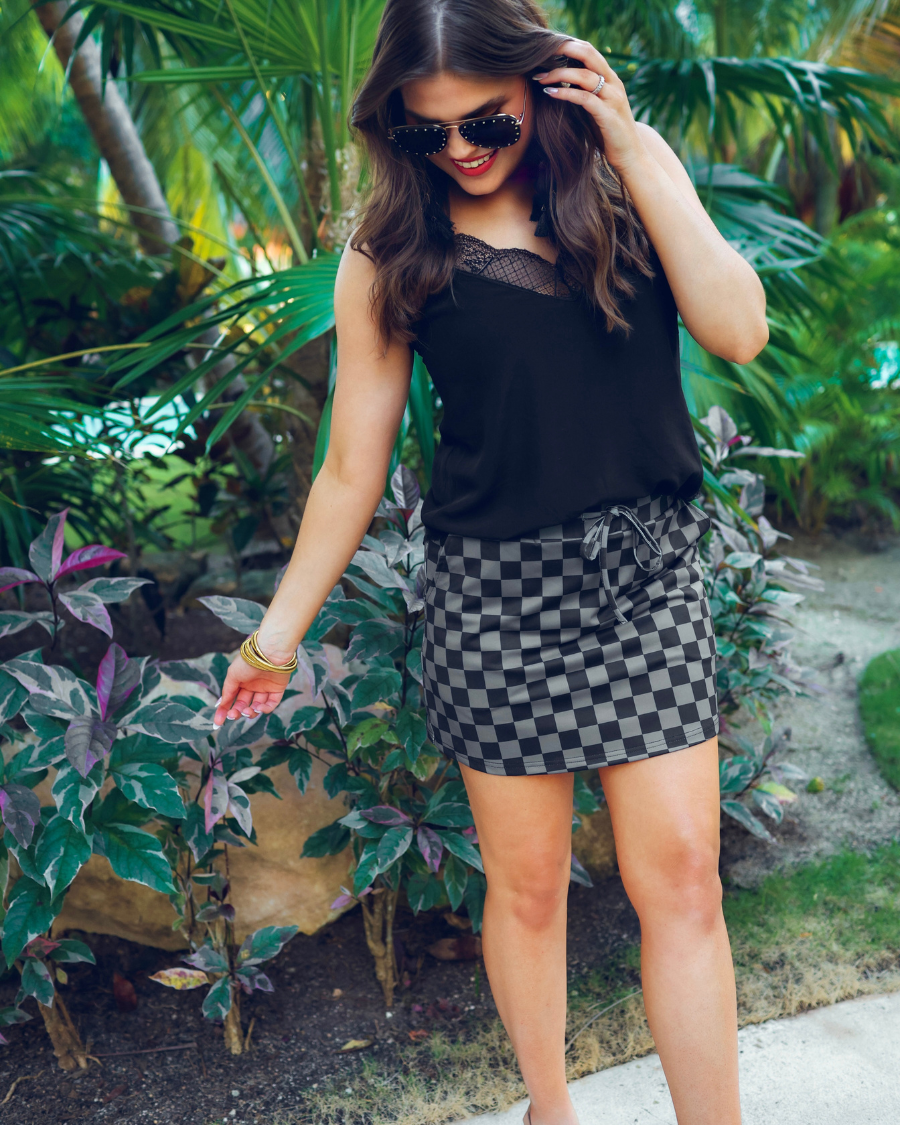 mid-rise relaxed fit everyday skort made of lightweight material with built-in black shorts, drawstring tie, an elastic band on the back, and side pockets, designed on a two-tone black checkered pattern print