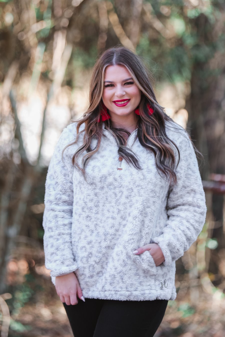 a long-sleeve fluffy pullover with a quarter zip, convenient front pockets, and a foldable collar on a neutral leopard print sherpa fabric