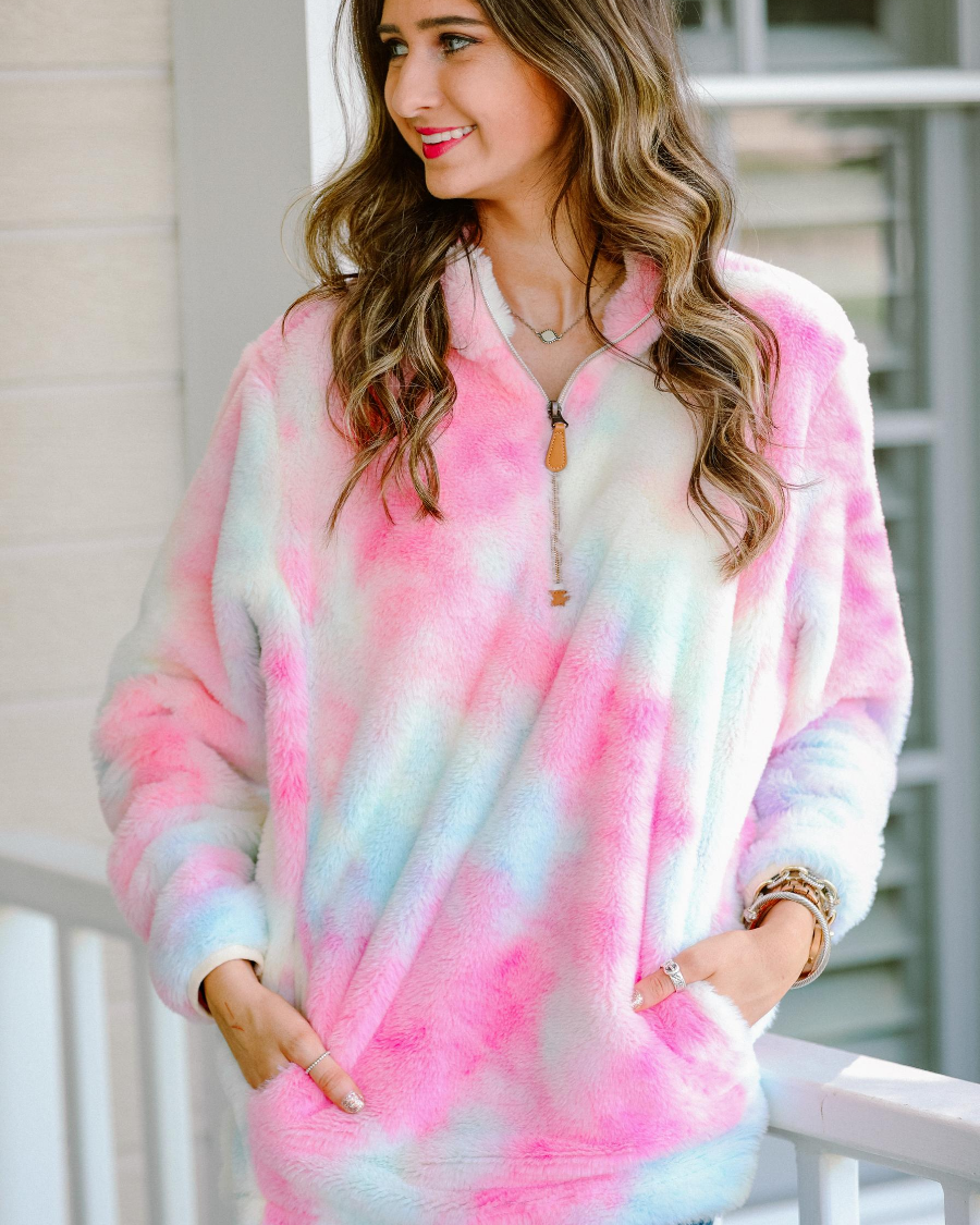 a long-sleeve plush pullover with a quarter zip, front pockets, and a foldable collar on a super soft tie-dye fabric