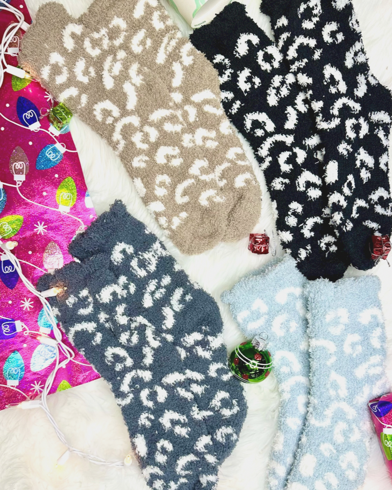 ultra-soft fuzzy socks with a playful animal print in black, blue, grey, and tan