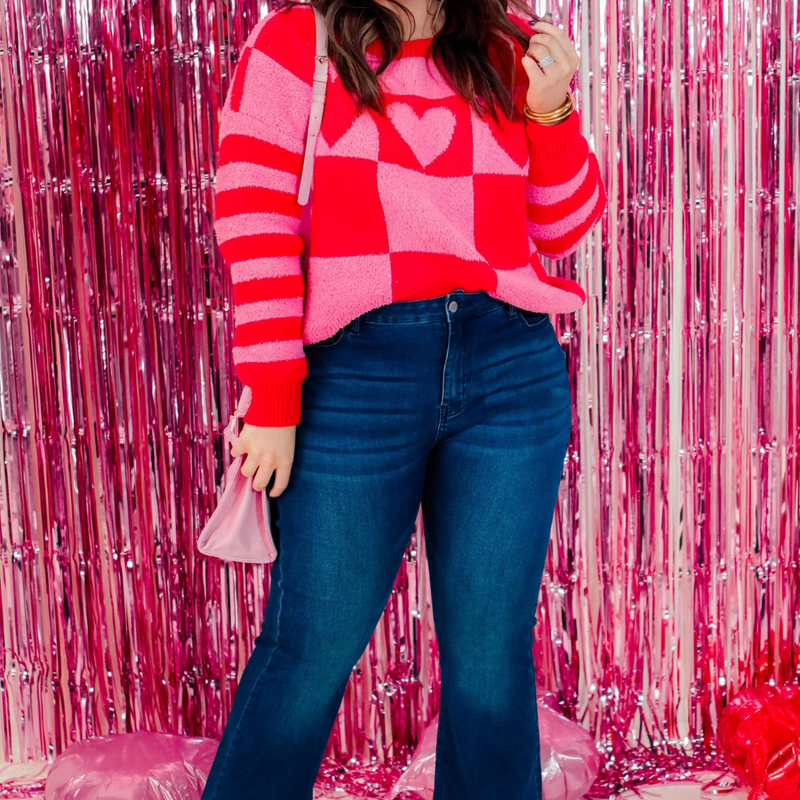 a plush fuzzy knit long-sleeve sweater with a playful mix of checkered blocks, heart motifs, and stripes on contrasting shades, a drop-shoulder fit, and ribbed detailing on the crew neckline, cuffs, and hemline