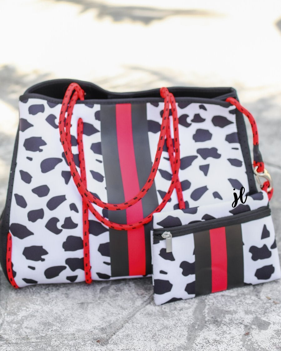 ultra-lightweight tote made of neoprene with removable hard bottom liner, paracord shoulder straps, removable matching zippered pouch, magnetic side snap closures in silver hardware, black interior (tote and pouch), and racing stripes (black and red) on black and red dalmation print pattern