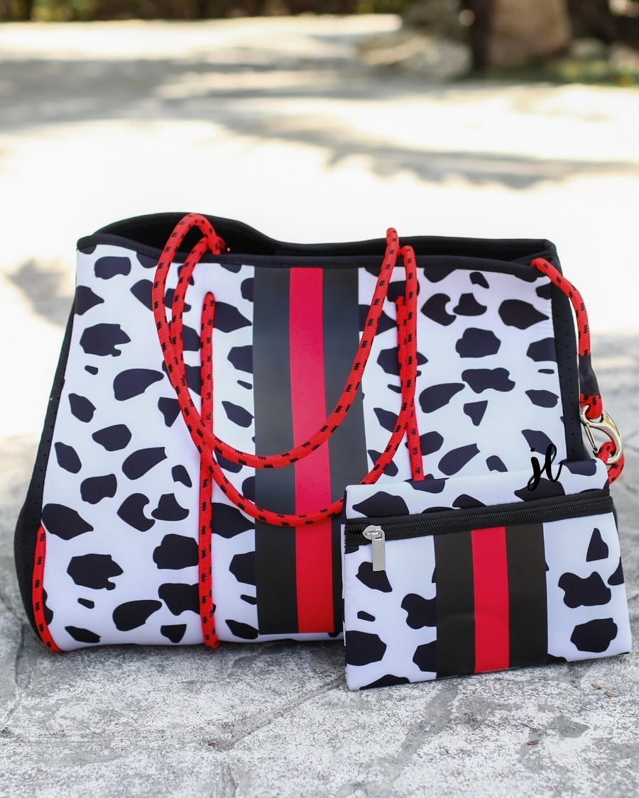 ultra-lightweight tote made of neoprene with removable hard bottom liner, paracord shoulder straps, removable matching zippered pouch, magnetic side snap closures in silver hardware, black interior (tote and pouch), and racing stripes (black and red) on black and red dalmation print pattern