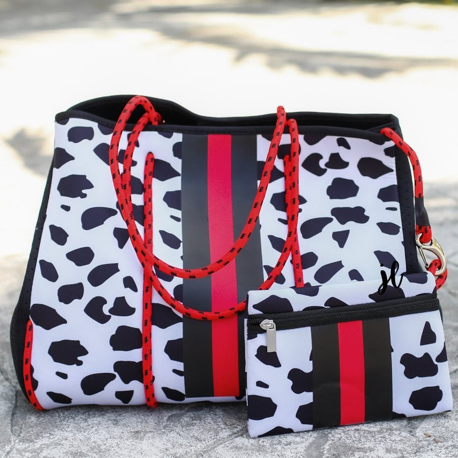 ultra-lightweight tote made of neoprene with removable hard bottom liner, paracord shoulder straps, removable matching zippered pouch, magnetic side snap closures in silver hardware, black interior (tote and pouch), and racing stripes (black and red) on black and red dalmation print pattern