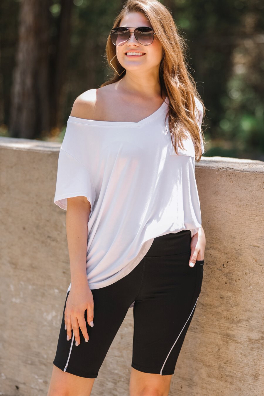 sleek black biker shorts created from lightweight stretch fabric with a white piping, high elastic waistband for tummy control, side pockets, a flattering figure-hugging short silhouette, above-knee length, and pull-on design