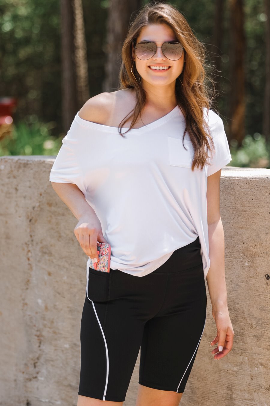 sleek black biker shorts created from lightweight stretch fabric with a white piping, high elastic waistband for tummy control, side pockets, a flattering figure-hugging short silhouette, above-knee length, and pull-on design