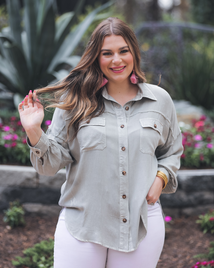 loose long-sleeve top made of soft lightweight material with a button up front, a collared neckline, button closure cuffs, two oversized accent chest pockets, and a slouched silhouette that falls into a rounded hemline with an oversized fit on an acid-washed colored fabric in grey