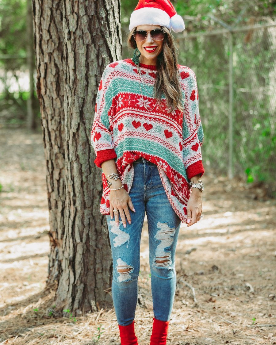three-quarter cuffed sleeve unlined sweater crafted from a lose knit material with an oversized fit, a rounded neckline, a chest pocket, and red trim on the collar, hem, and pocket on a seasonal pattern (geometric designs, hearts, and snowflakes)