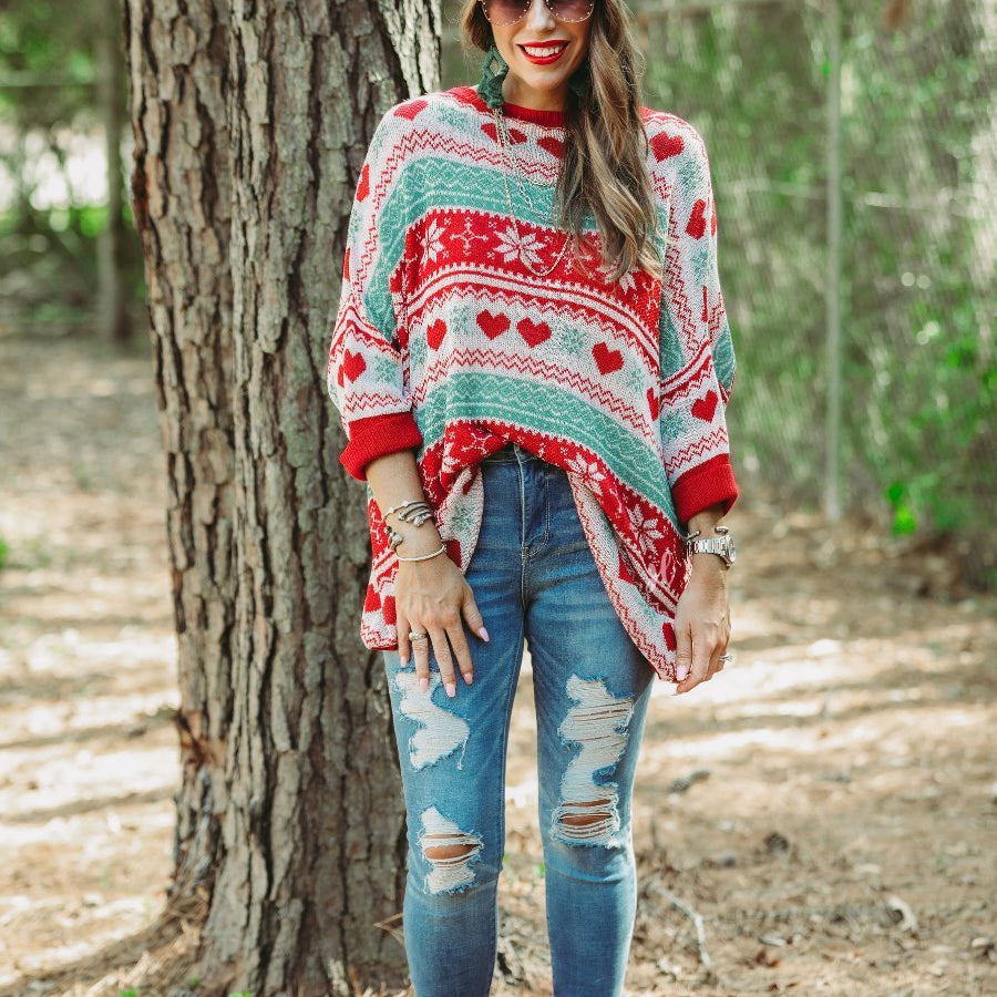 three-quarter cuffed sleeve unlined sweater crafted from a lose knit material with an oversized fit, a rounded neckline, a chest pocket, and red trim on the collar, hem, and pocket on a seasonal pattern (geometric designs, hearts, and snowflakes)
