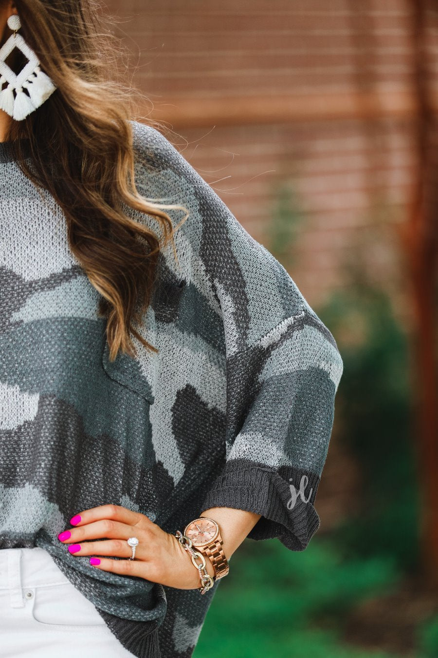 three-quarter cuffed sleeve unlined sweater crafted from a loose knit material with an oversized fit, a rounded neckline, a chest pocket, and trim on the collar, hem, and pocket on a grey camouflage pattern and charcoal base