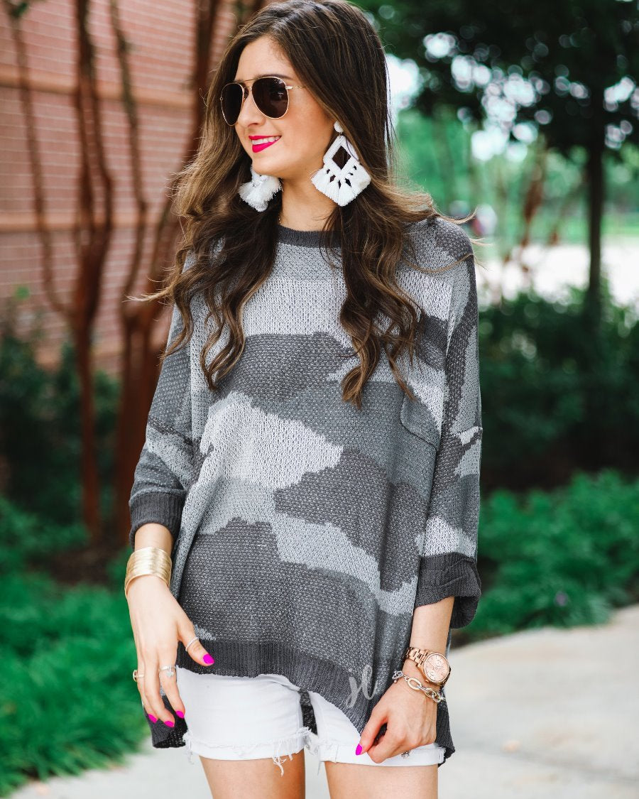 three-quarter cuffed sleeve unlined sweater crafted from a loose knit material with an oversized fit, a rounded neckline, a chest pocket, and trim on the collar, hem, and pocket on a grey camouflage pattern and charcoal base