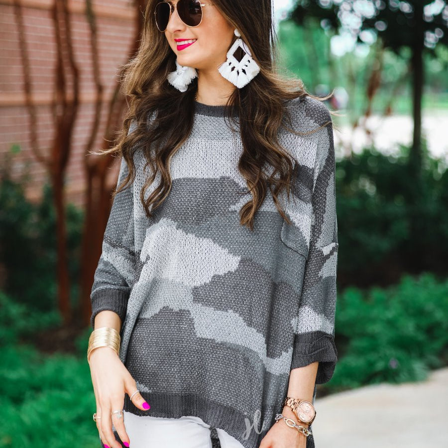 three-quarter cuffed sleeve unlined sweater crafted from a loose knit material with an oversized fit, a rounded neckline, a chest pocket, and trim on the collar, hem, and pocket on a grey camouflage pattern and charcoal base