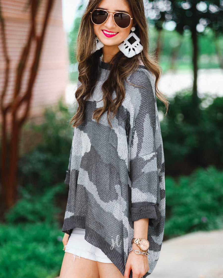 three-quarter cuffed sleeve unlined sweater crafted from a loose knit material with an oversized fit, a rounded neckline, a chest pocket, and trim on the collar, hem, and pocket on a grey camouflage pattern and charcoal base
