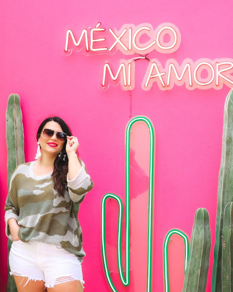 three-quarter cuffed sleeve unlined sweater crafted from a loose knit material with an oversized fit, a rounded neckline, a chest pocket, and trim on the collar, hem, and pocket on a green camouflage pattern and grey base