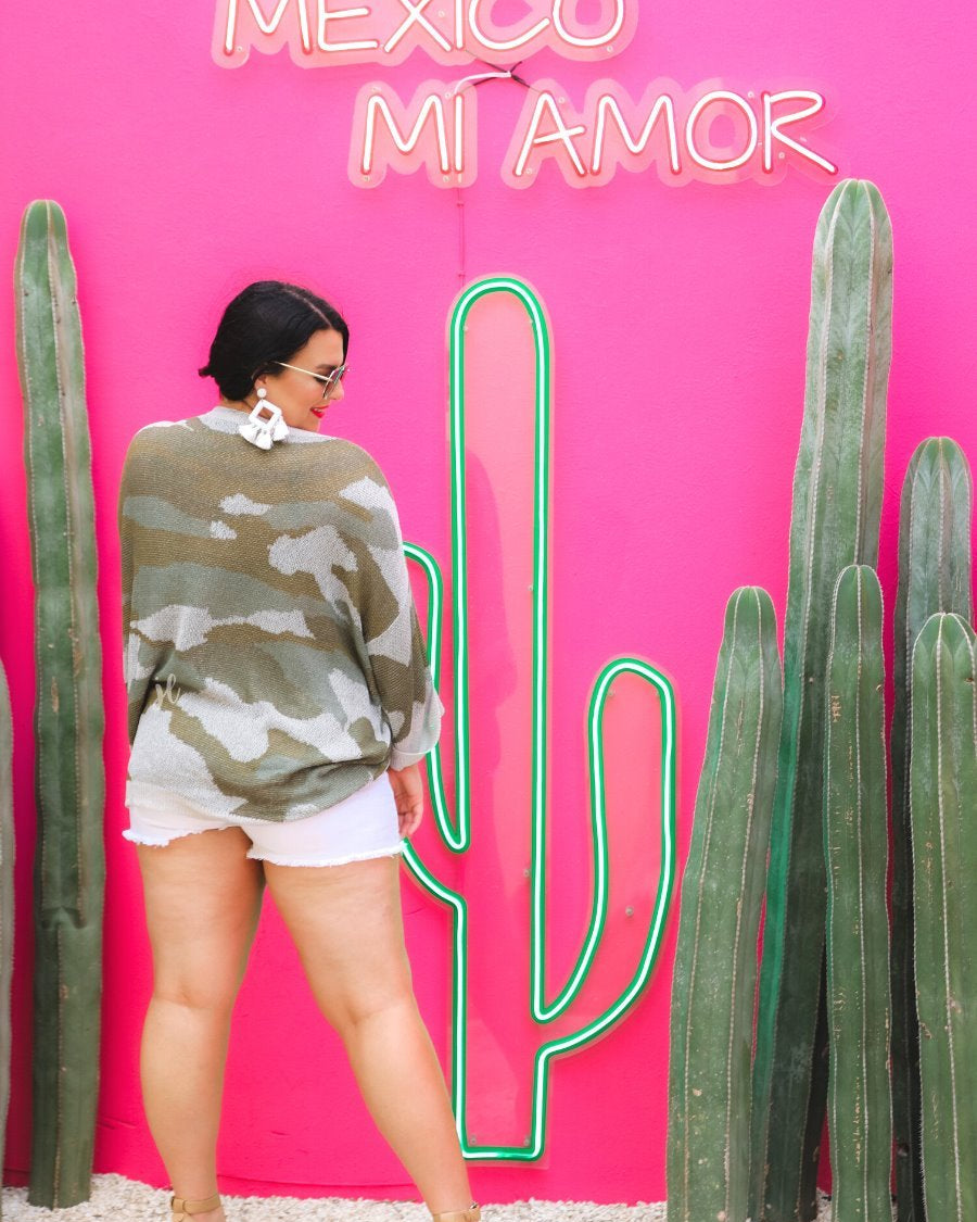 three-quarter cuffed sleeve unlined sweater crafted from a loose knit material with an oversized fit, a rounded neckline, a chest pocket, and trim on the collar, hem, and pocket on a green camouflage pattern and grey base