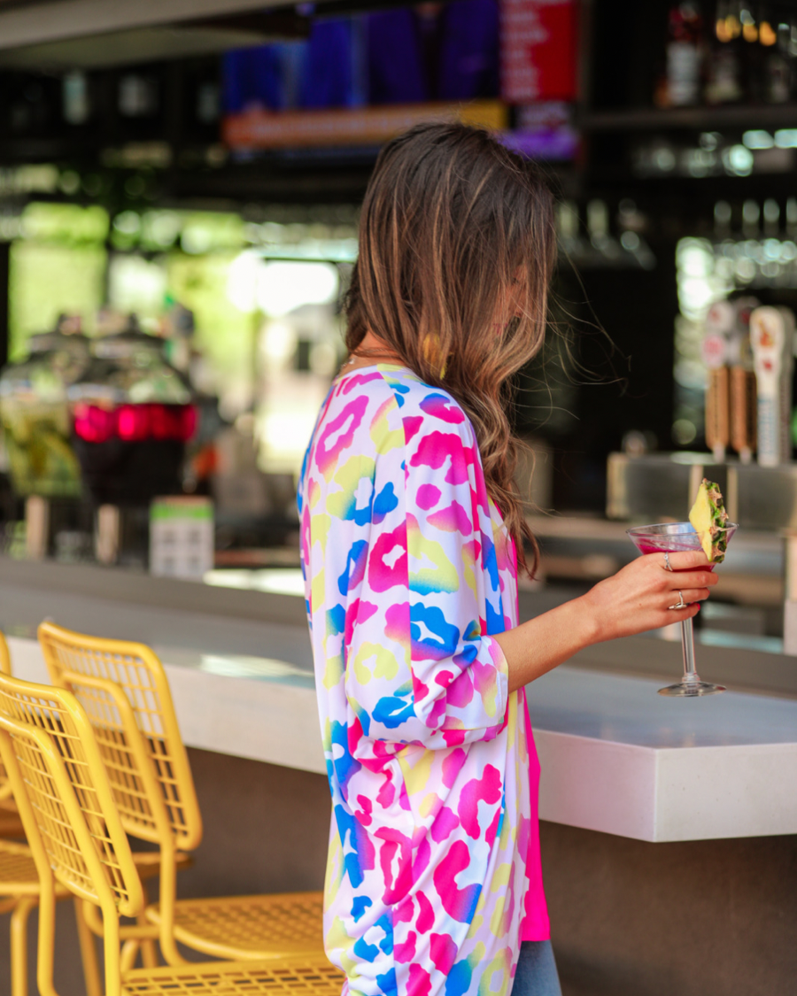 three-quarter sleeve open front cardigan made of lightweight material that drapes into a cocoon shape on a vibrant leopard print pattern fabric in white