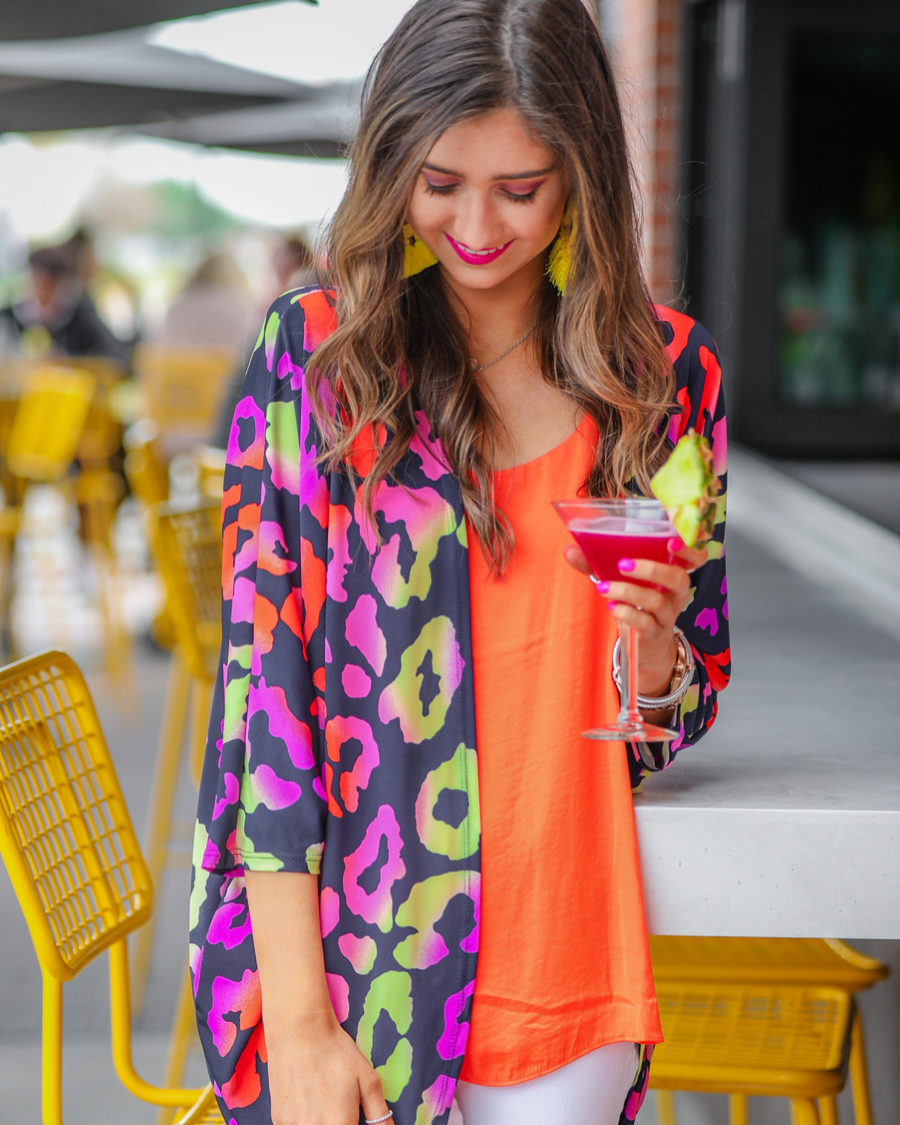 three-quarter sleeve open front cardigan made of lightweight material that drapes into a cocoon shape on a vibrant leopard print pattern fabric in navy