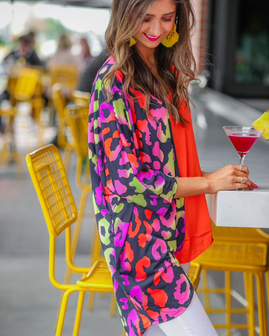 three-quarter sleeve open front cardigan made of lightweight material that drapes into a cocoon shape on a vibrant leopard print pattern fabric in navy