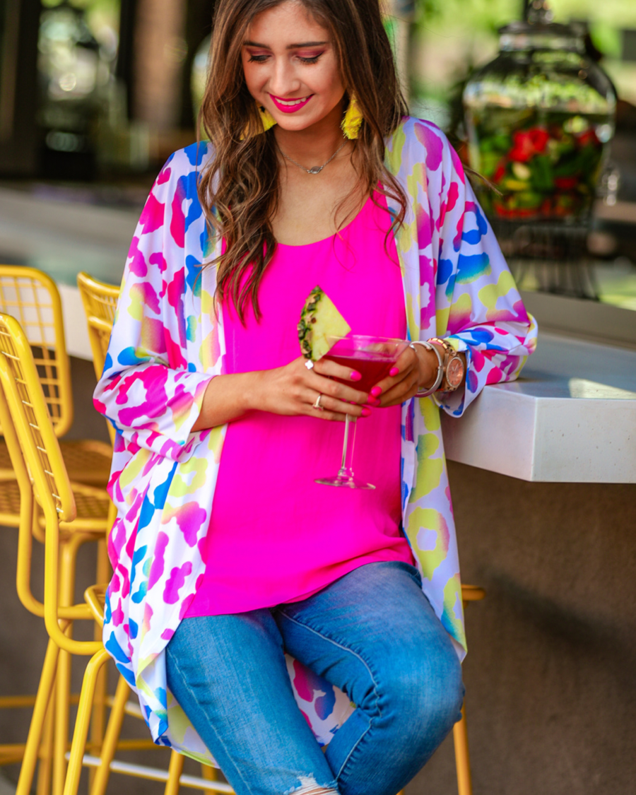 three-quarter sleeve open front cardigan made of lightweight material that drapes into a cocoon shape on a vibrant leopard print pattern fabric in white