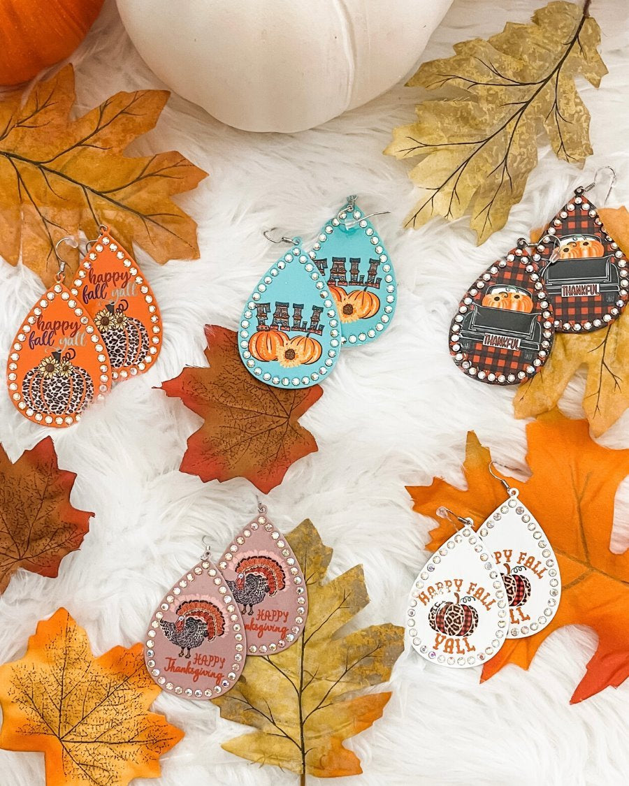 lightweight, seasonal-inspired leopard-theme teardrop-shaped earrings outlined in rhinestones with a fish hook in mauve leopard pumpkin, orange leopard pumpkin, plaid pumpkin truck, teal pumpkin, and white leopard pumpkin