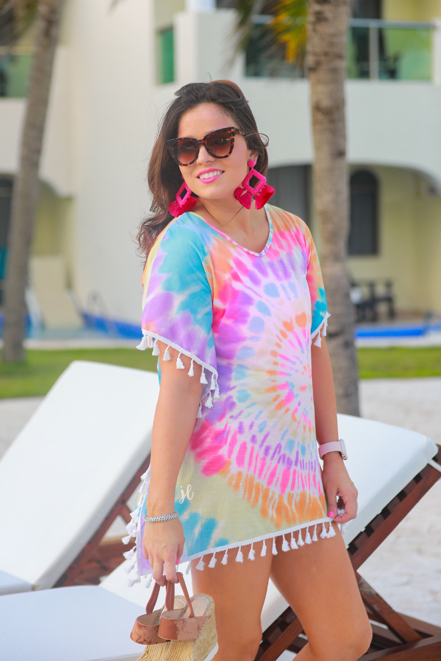 short sleeve lightweight coverup made of breathable fabric with a vibrant tie-dye print pattern, a high v-neckline, open sides with an arm opening, and side tassels