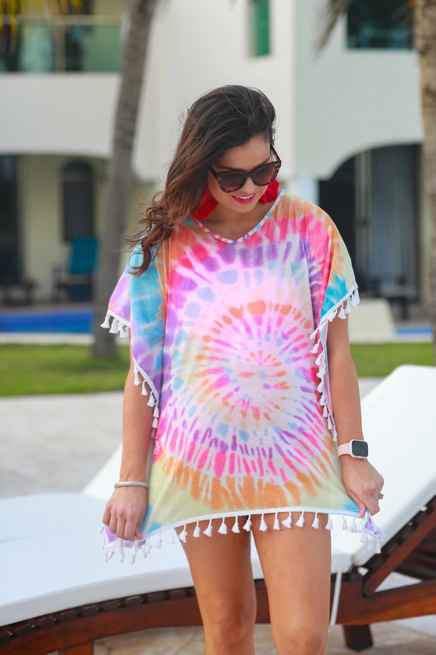 short sleeve lightweight coverup made of breathable fabric with a vibrant tie-dye print pattern, a high v-neckline, open sides with an arm opening, and side tassels