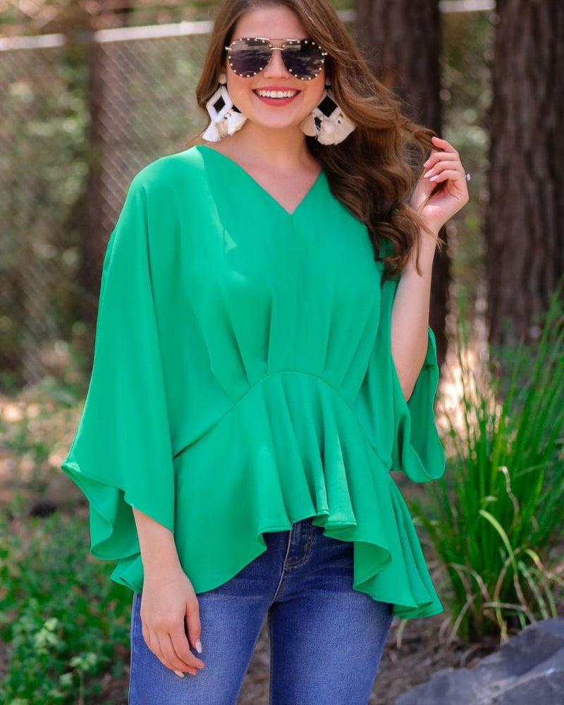 dolman long sleeves top with a plunging
v-neckline and a gathered waistline in green