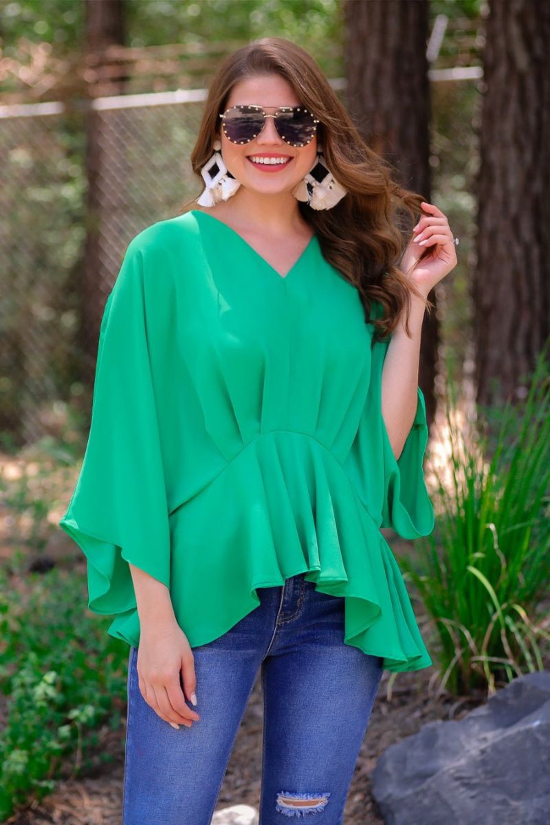 dolman long sleeves top with a plunging
v-neckline and a gathered waistline in green