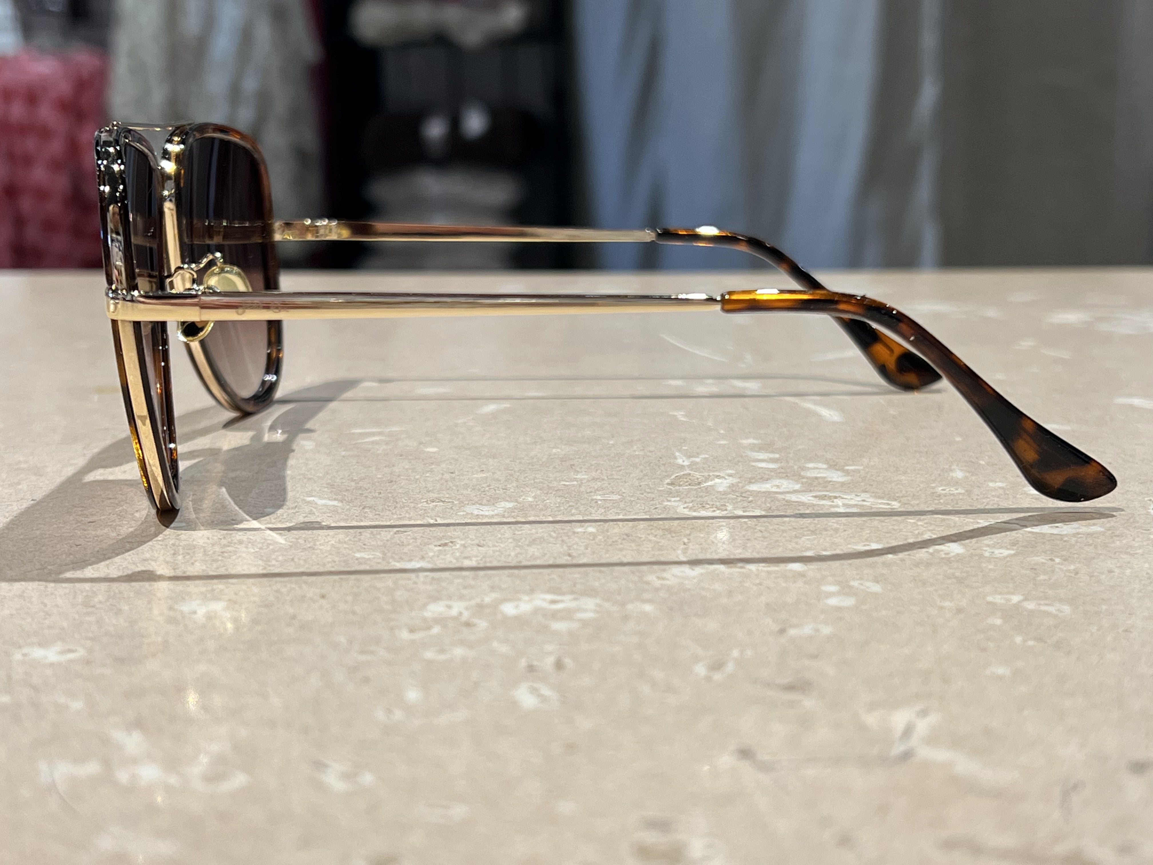 brown aviator sunglasses with thin round wireframes, tinted lenses, UV protection, and brand name detail (on both the temple and the complimentary black pouch)