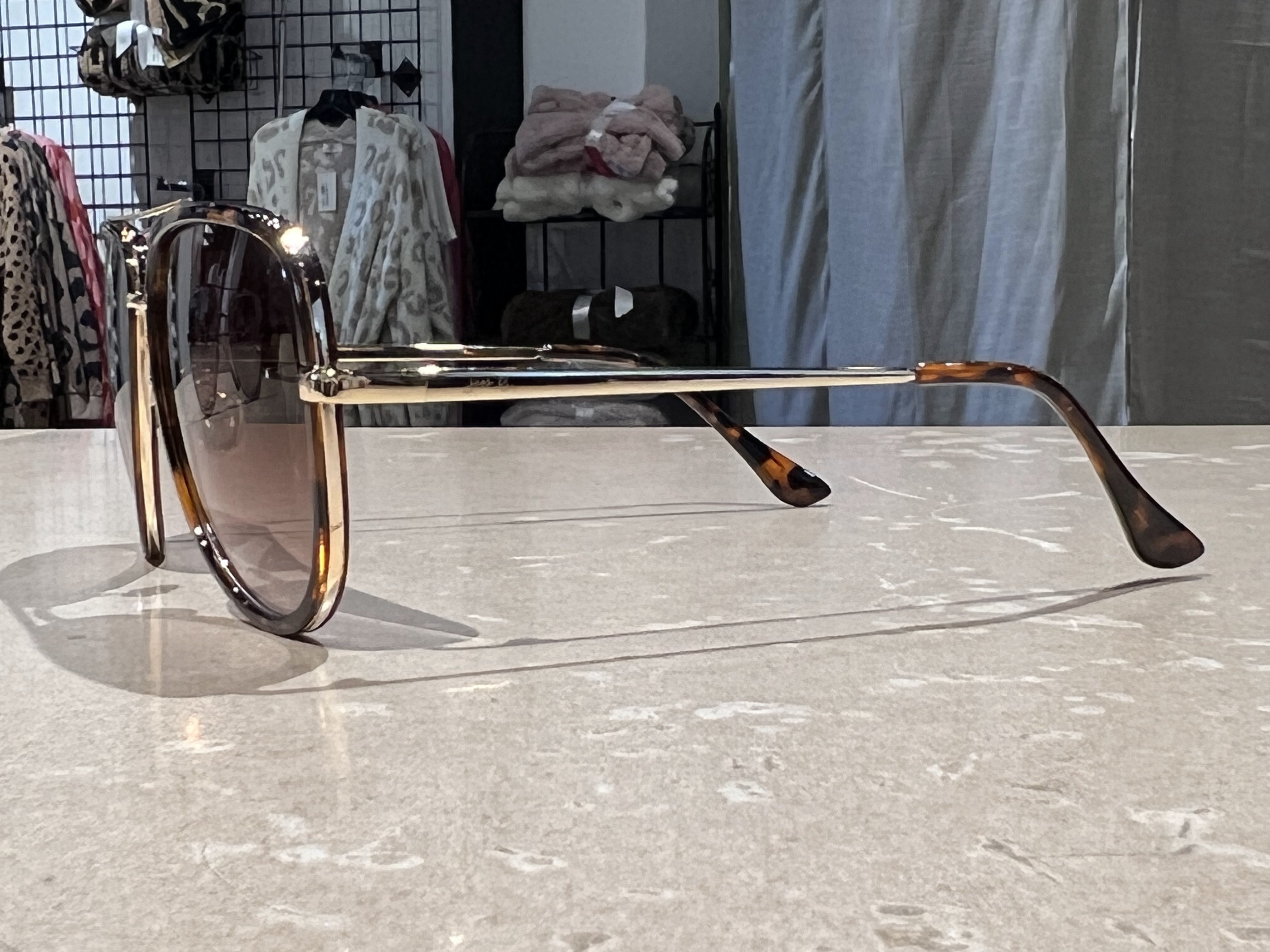 brown aviator sunglasses with thin round wireframes, tinted lenses, UV protection, and brand name detail (on both the temple and the complimentary black pouch)