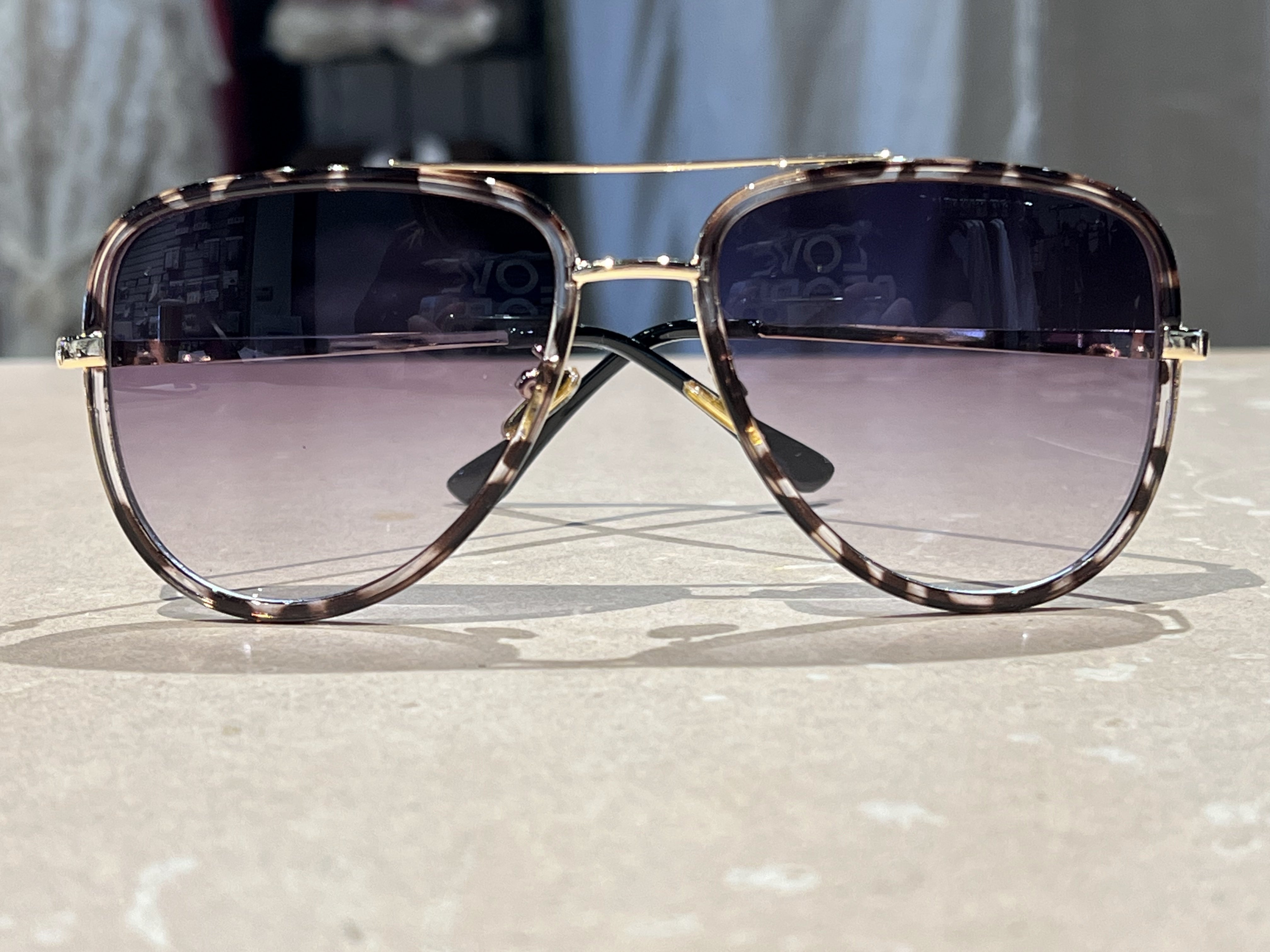 grey aviator sunglasses with thin round wireframes, tinted lenses, UV protection, and brand name detail (on both the temple and the complimentary black pouch)