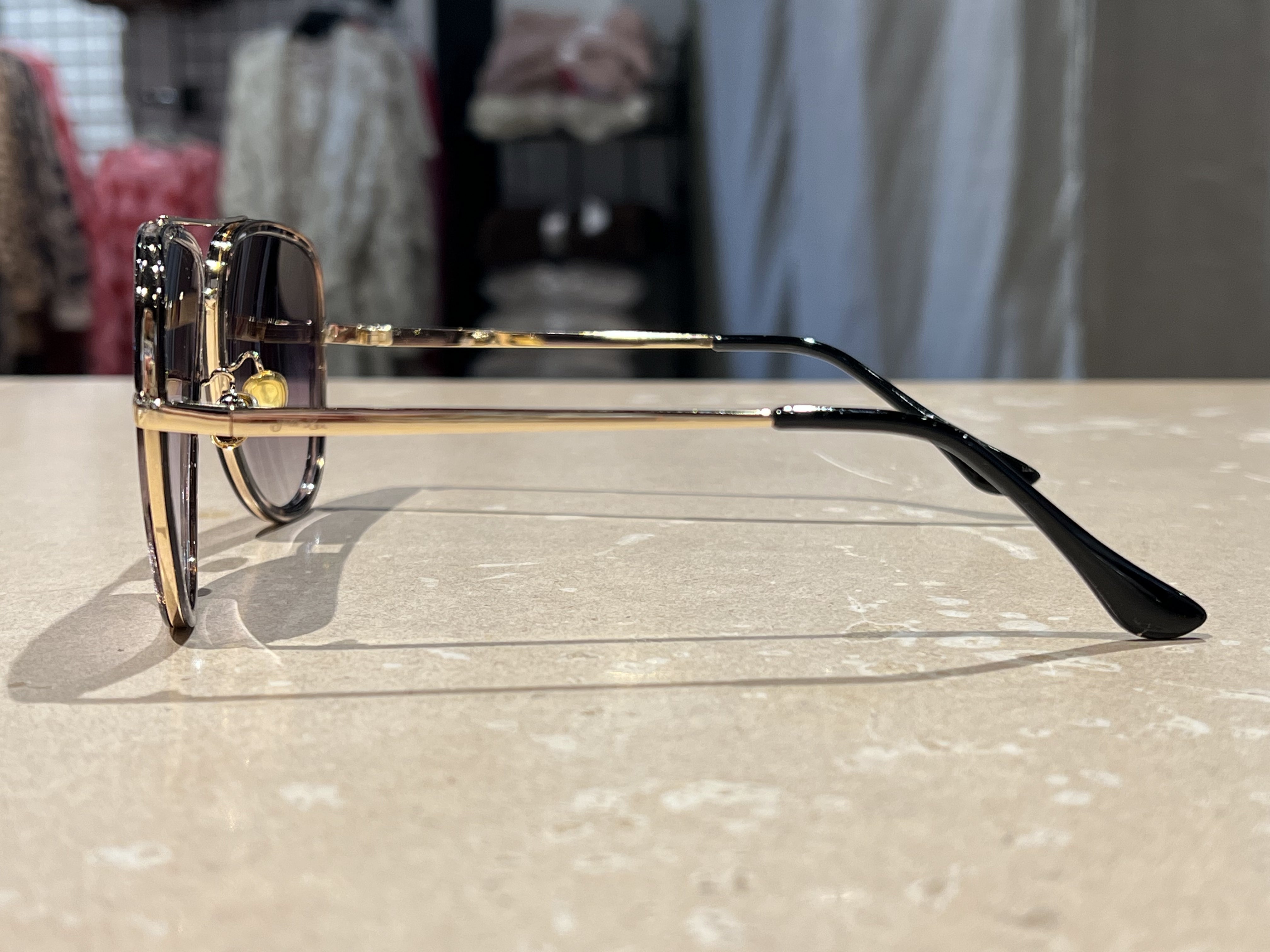 grey aviator sunglasses with thin round wireframes, tinted lenses, UV protection, and brand name detail (on both the temple and the complimentary black pouch)