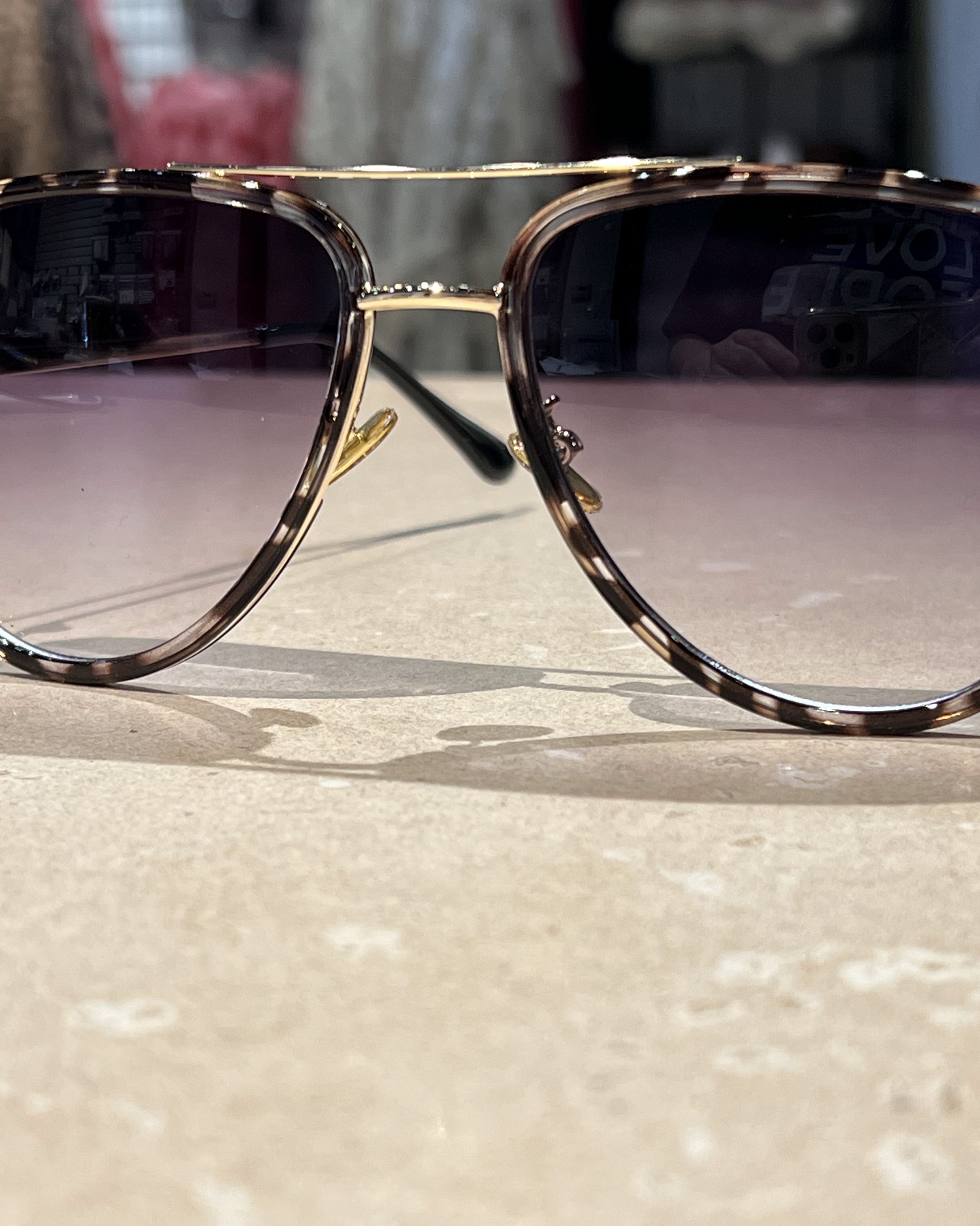 grey aviator sunglasses with thin round wireframes, tinted lenses, UV protection, and brand name detail (on both the temple and the complimentary black pouch)