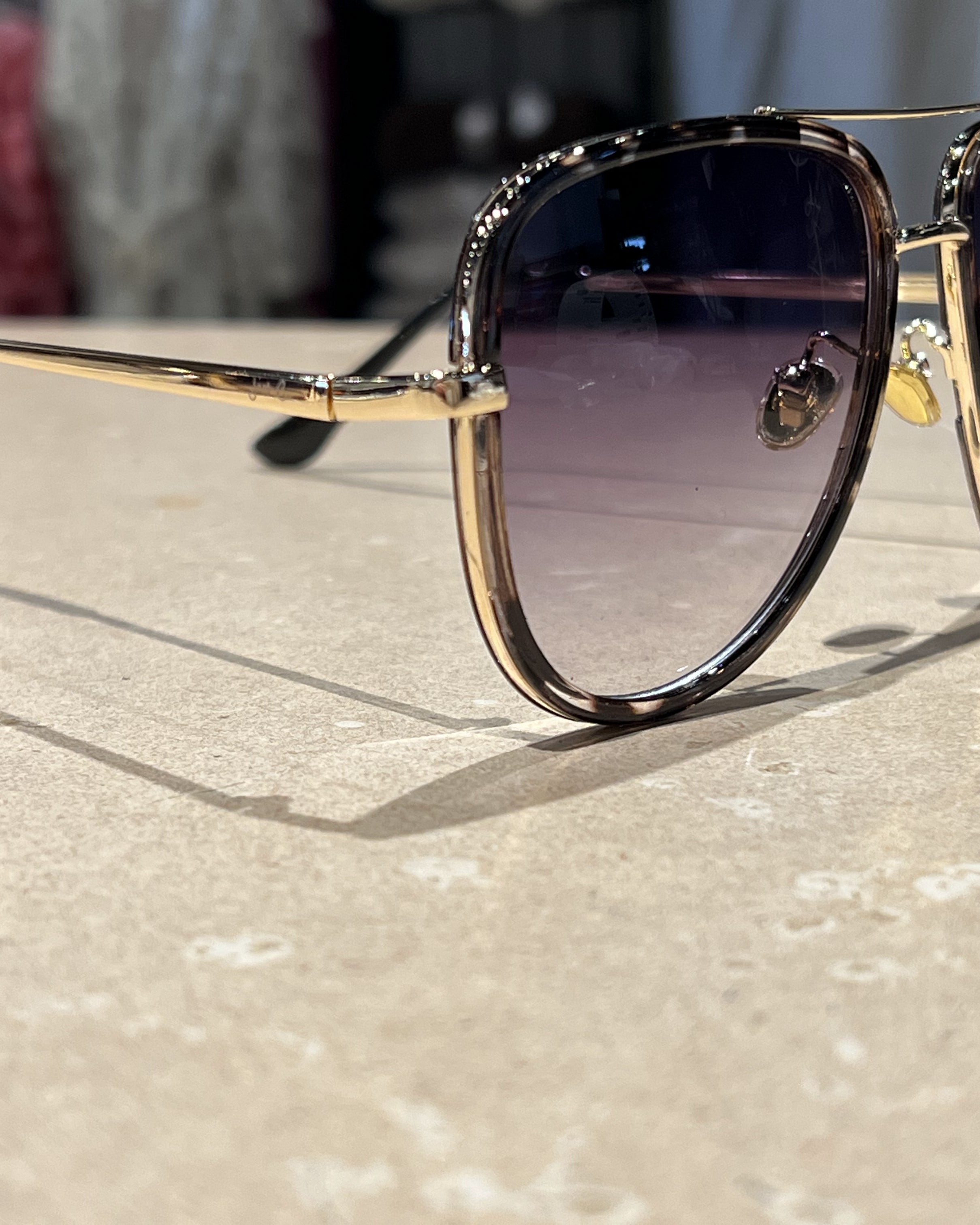 silver aviator sunglasses with thin round wireframes, tinted lenses, UV protection, and brand name detail (on both the temple and the complimentary black pouch)