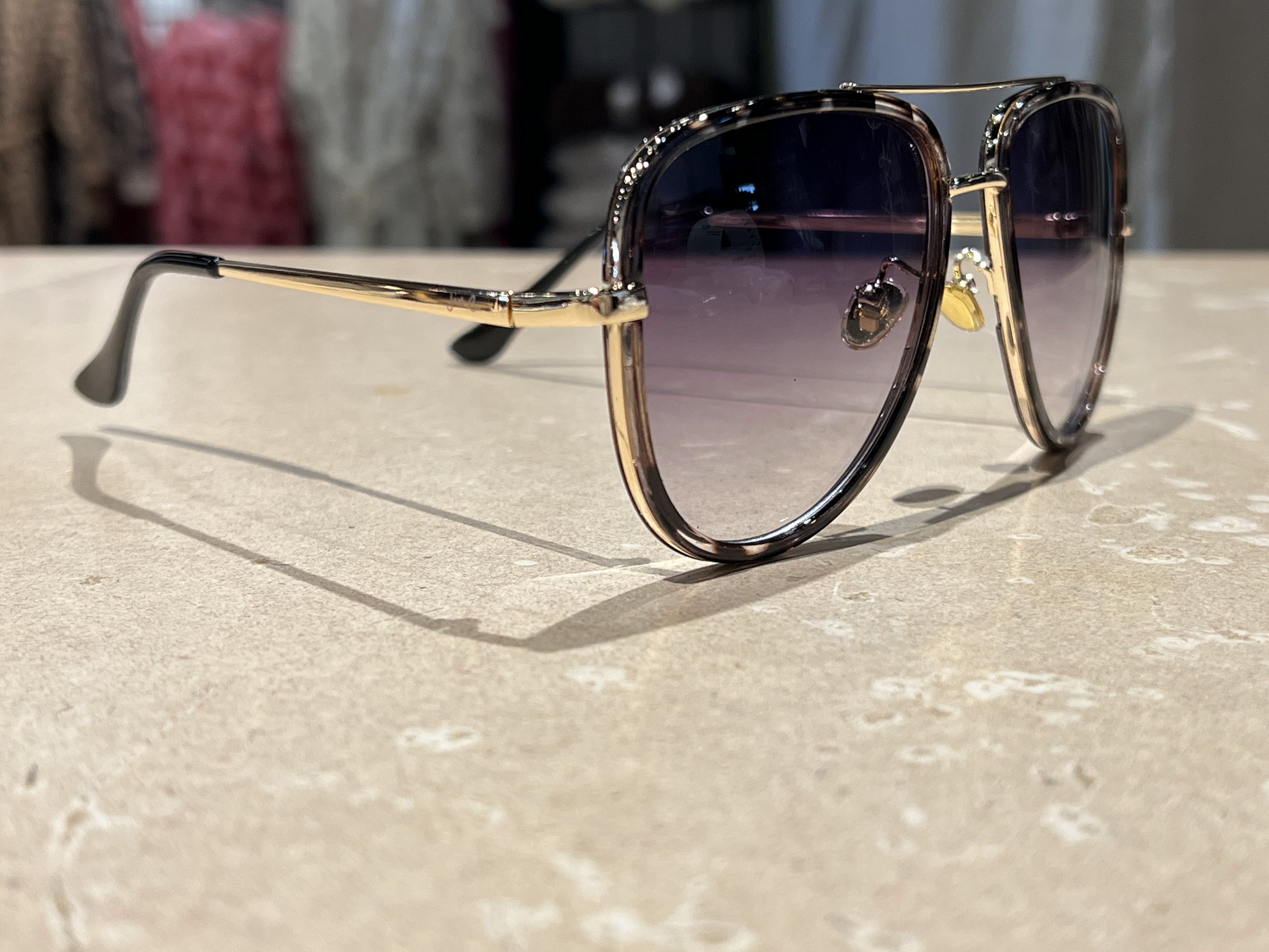 silver aviator sunglasses with thin round wireframes, tinted lenses, UV protection, and brand name detail (on both the temple and the complimentary black pouch)