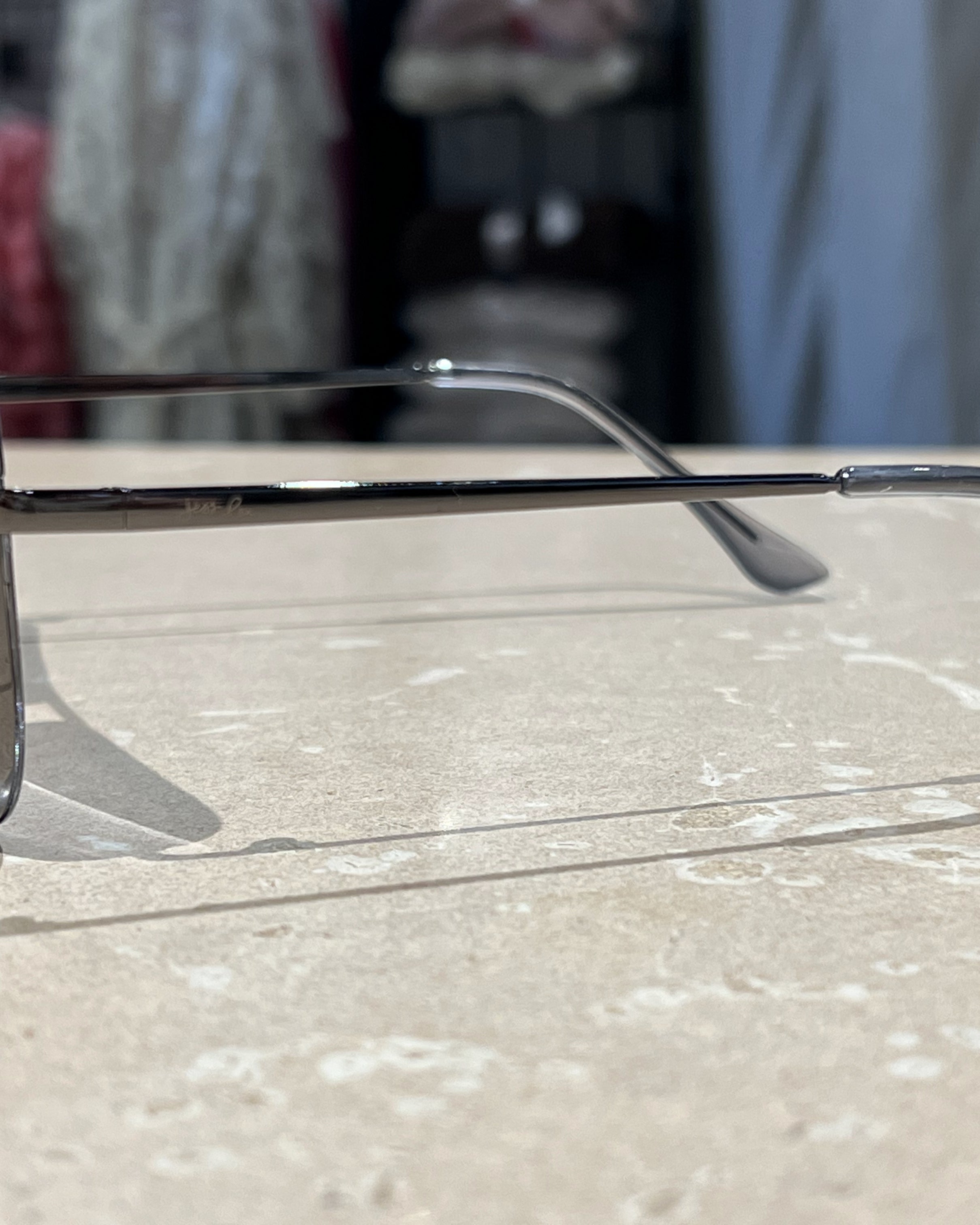 silver aviator sunglasses with thin round wireframes, tinted lenses, UV protection, and brand name detail (on both the temple and the complimentary black pouch)